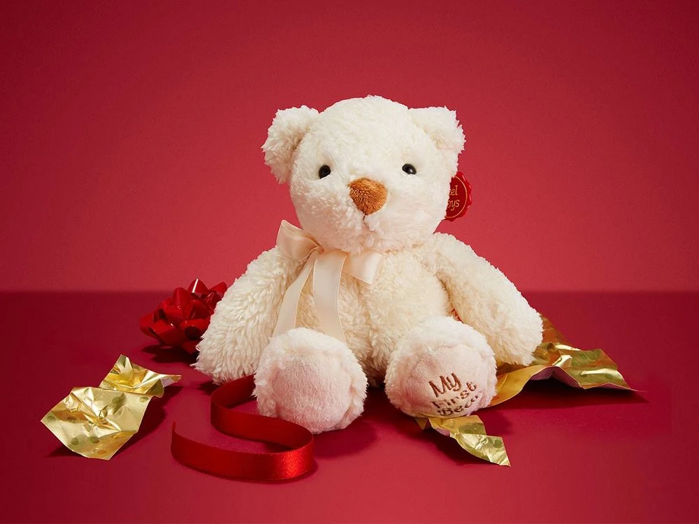 White teddy bear campaign product still on a red set for Tesco Guess That Gift